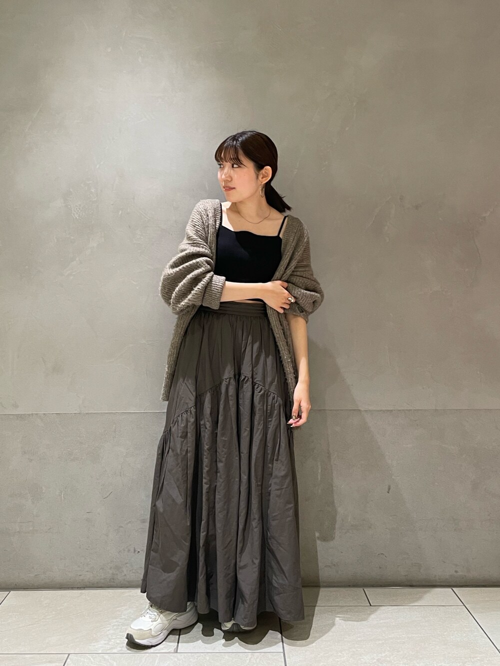 グレー系のカーディガン/ボレロ、グレー系のスカートを着用したレディースの秋コーディネートの2枚目の写真