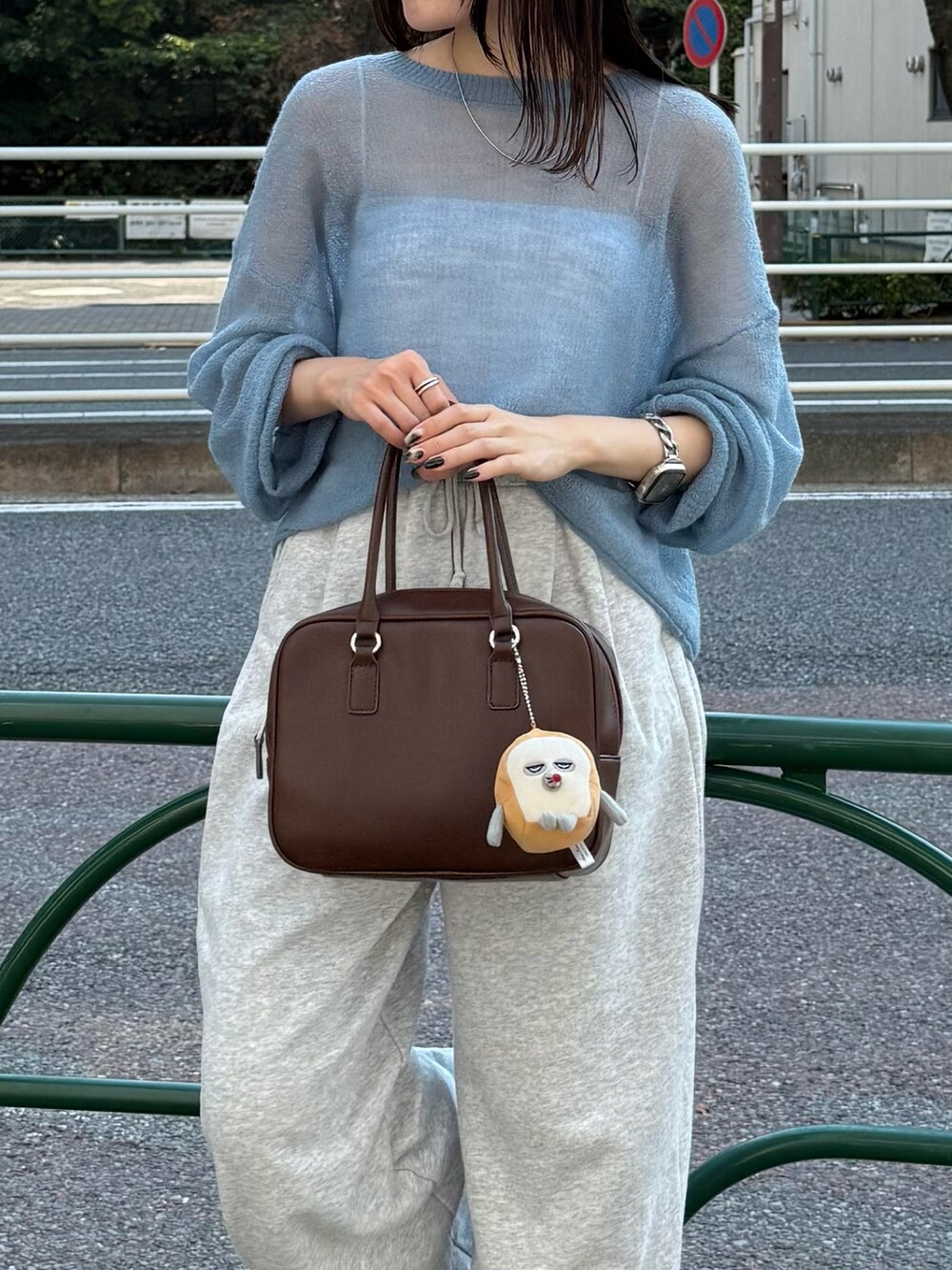 ブルー系のニット/セーター、ブラウン系のハンドバッグを着用したレディースの秋コーディネートの5枚目の写真