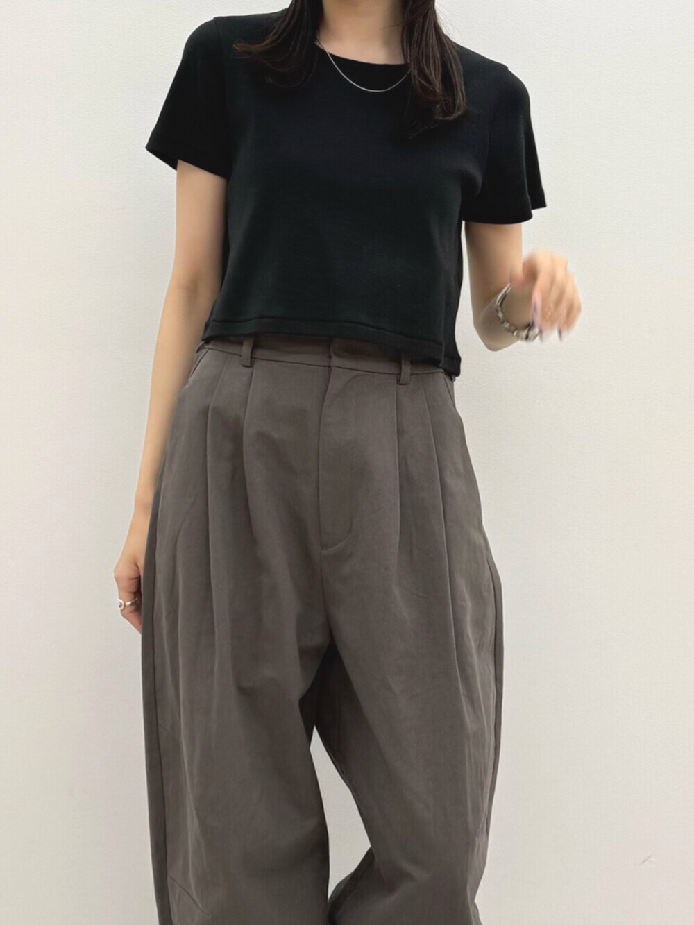 ブラック系のTシャツ/カットソー、グレー系のチノパンツ、ホワイト系のキャップを着用したレディースの春コーディネートの7枚目の写真