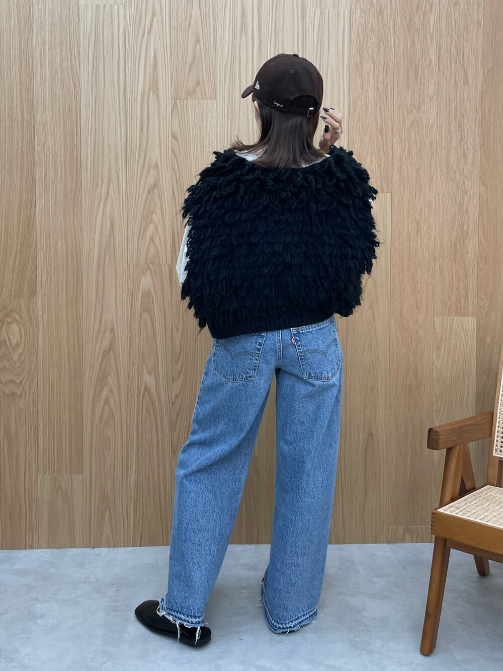 ブルー系のデニムパンツ、ブラック系のブーツ、グレー系のスウェットを着用したレディースの秋コーディネートの5枚目の写真