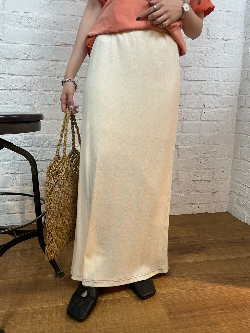 ホワイト系のスカート、イエロー系のハンドバッグ、ブラック系のパンプスを着用したレディースの春コーディネートの5枚目の写真