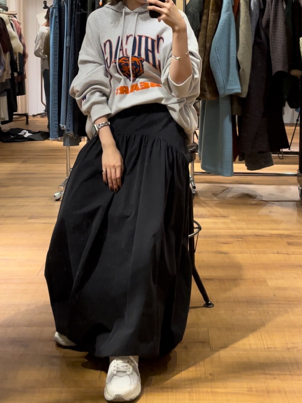 ブラック系のスカート、グレー系のパーカーを着用したレディースの秋コーディネートの3枚目の写真