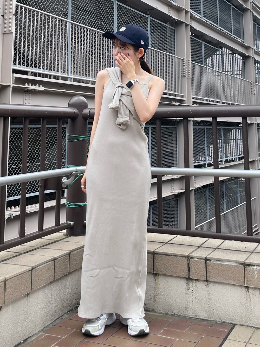 グレー系のワンピース、ブルー系のデニムジャケット、ブルー系のキャップを着用したレディースの夏コーディネートの6枚目の写真