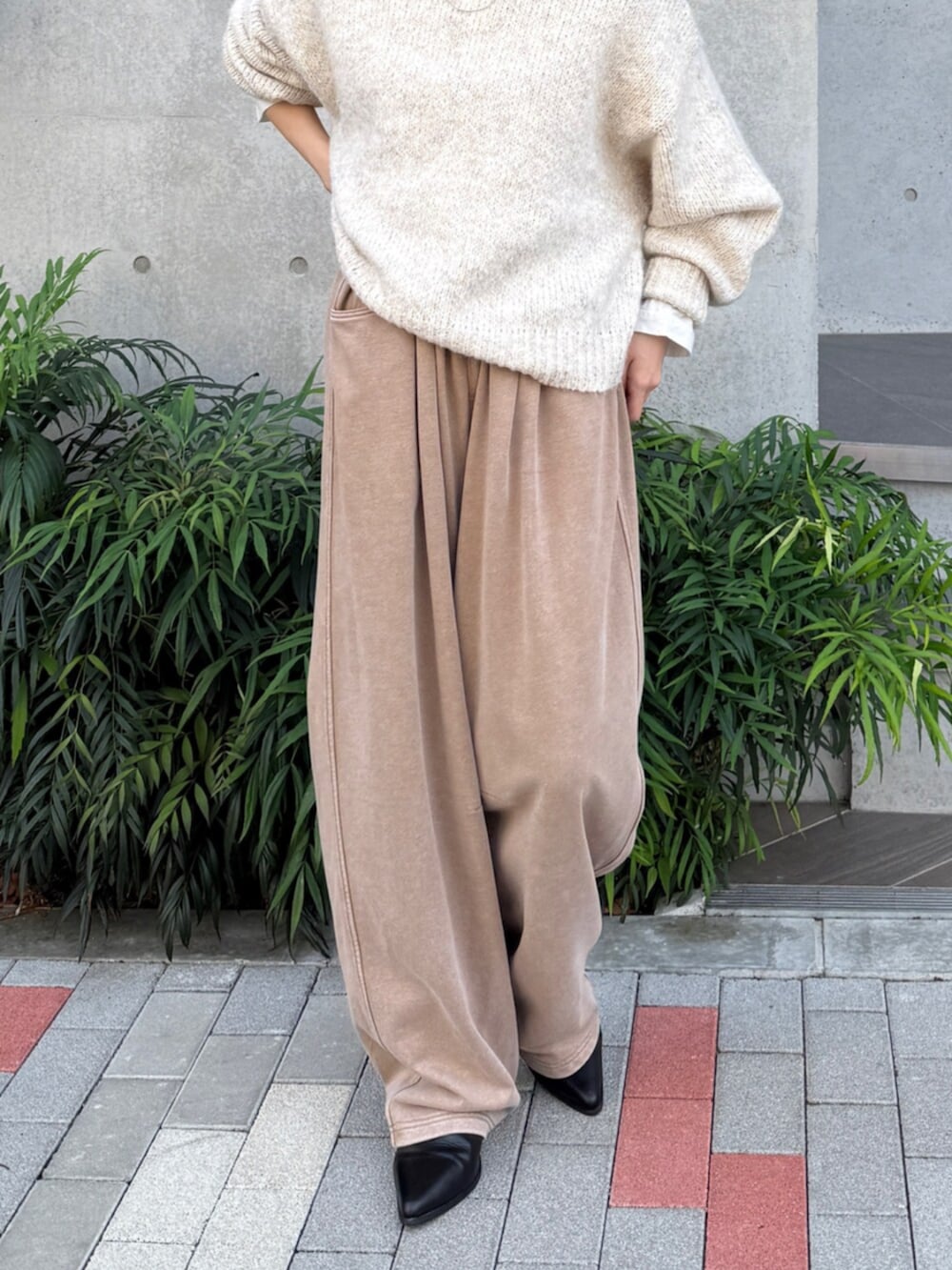 ベージュ系のスウェットパンツ、ブラック系のブーツ、ホワイト系のTシャツ/カットソーを着用したレディースの秋コーディネートの7枚目の写真