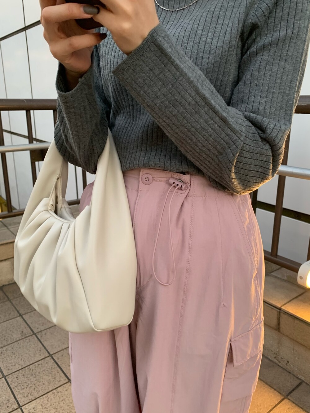 ピンク系のカーゴパンツ、ホワイト系のハンドバッグ、グレー系のニット/セーターを着用したレディースの冬コーディネートの6枚目の写真