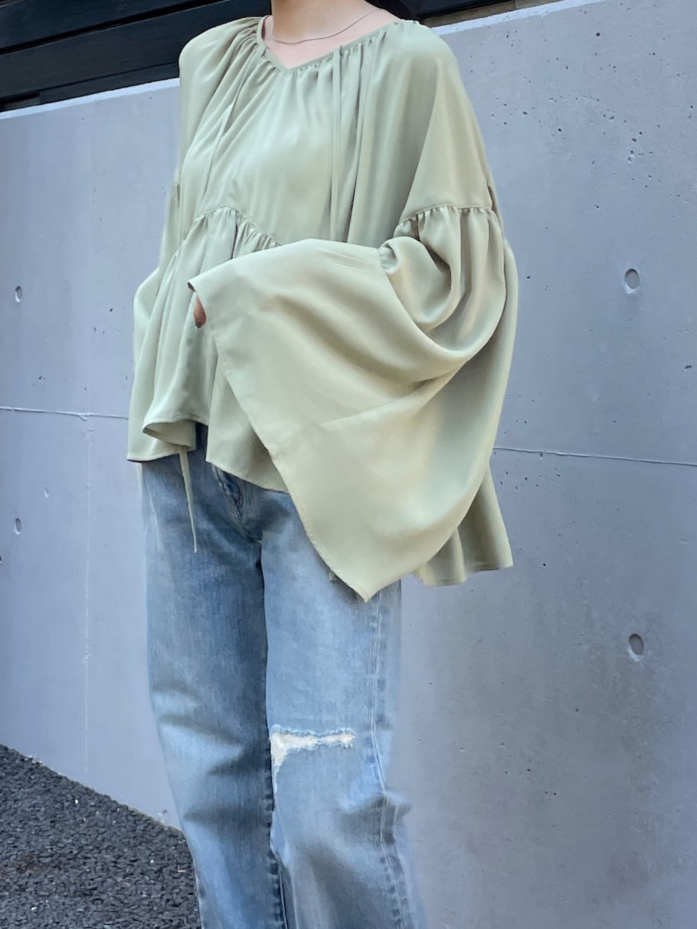 ブルー系のデニムパンツ、シルバー系のバレエシューズ、グリーン系のシャツ/ブラウスを着用したレディースの春コーディネートの7枚目の写真