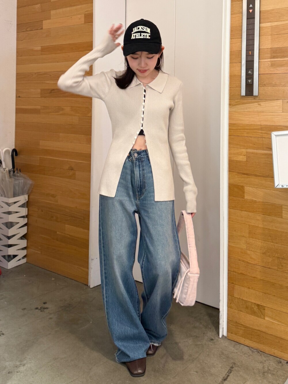 ブラウン系のブーツ、ブルー系のデニムパンツ、ピンク系のハンドバッグを着用したレディースの秋コーディネートの5枚目の写真