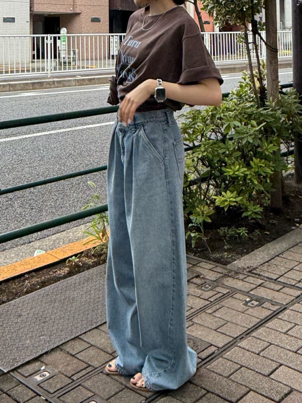 ブラック系のサンダル、ブルー系のデニムパンツ、ブラウン系のTシャツ/カットソーを着用したレディースの夏コーディネートの6枚目の写真