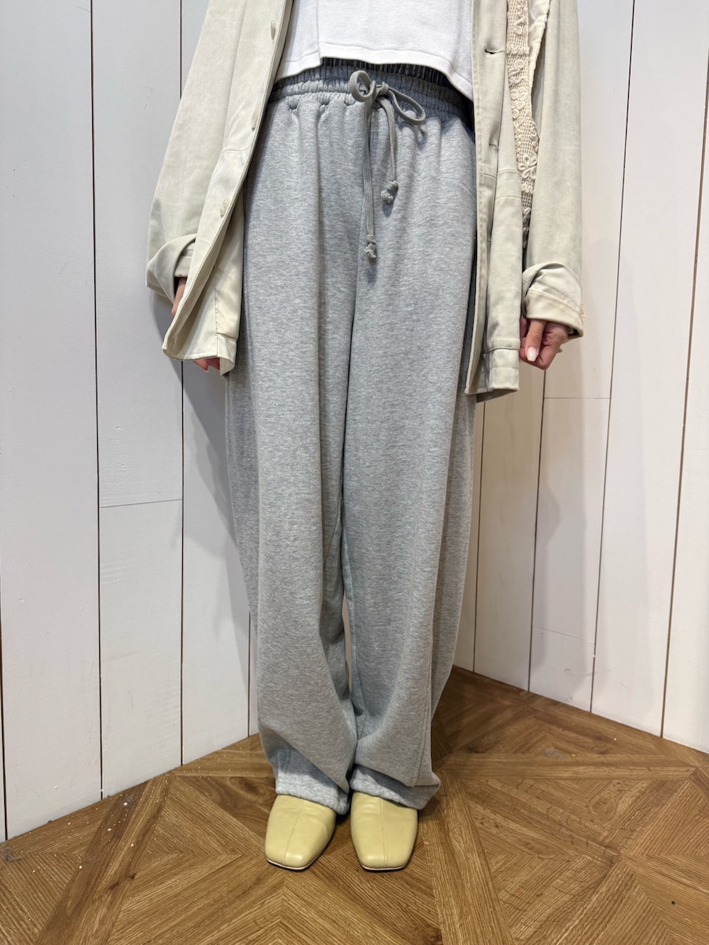 グレー系のスウェットパンツ、イエロー系のサンダル、ホワイト系のテーラードジャケットを着用したレディースの春コーディネートの5枚目の写真