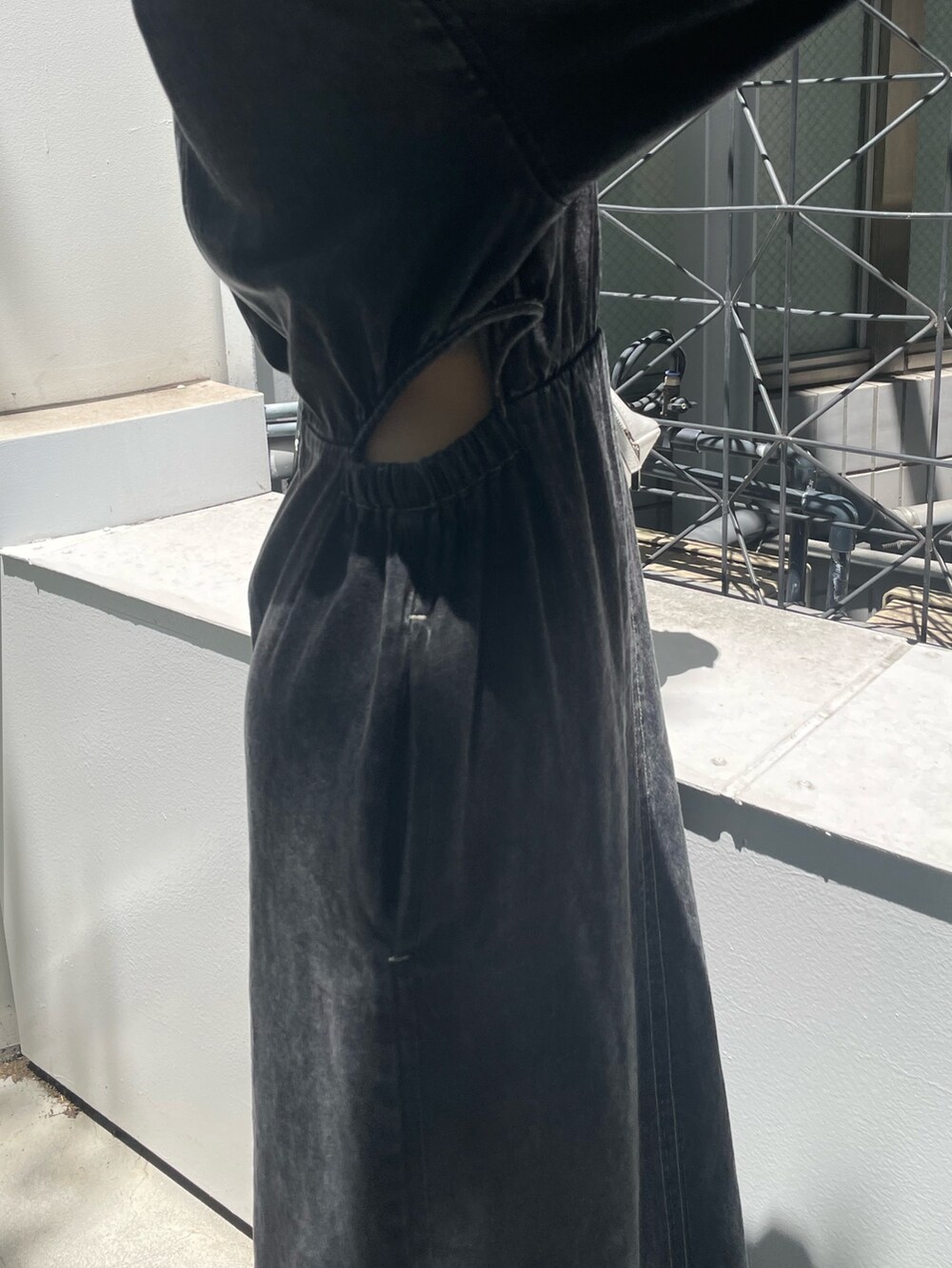 ホワイト系のハンドバッグ、ブラック系のブーツ、ブラック系のワンピースを着用したレディースの夏コーディネートの6枚目の写真