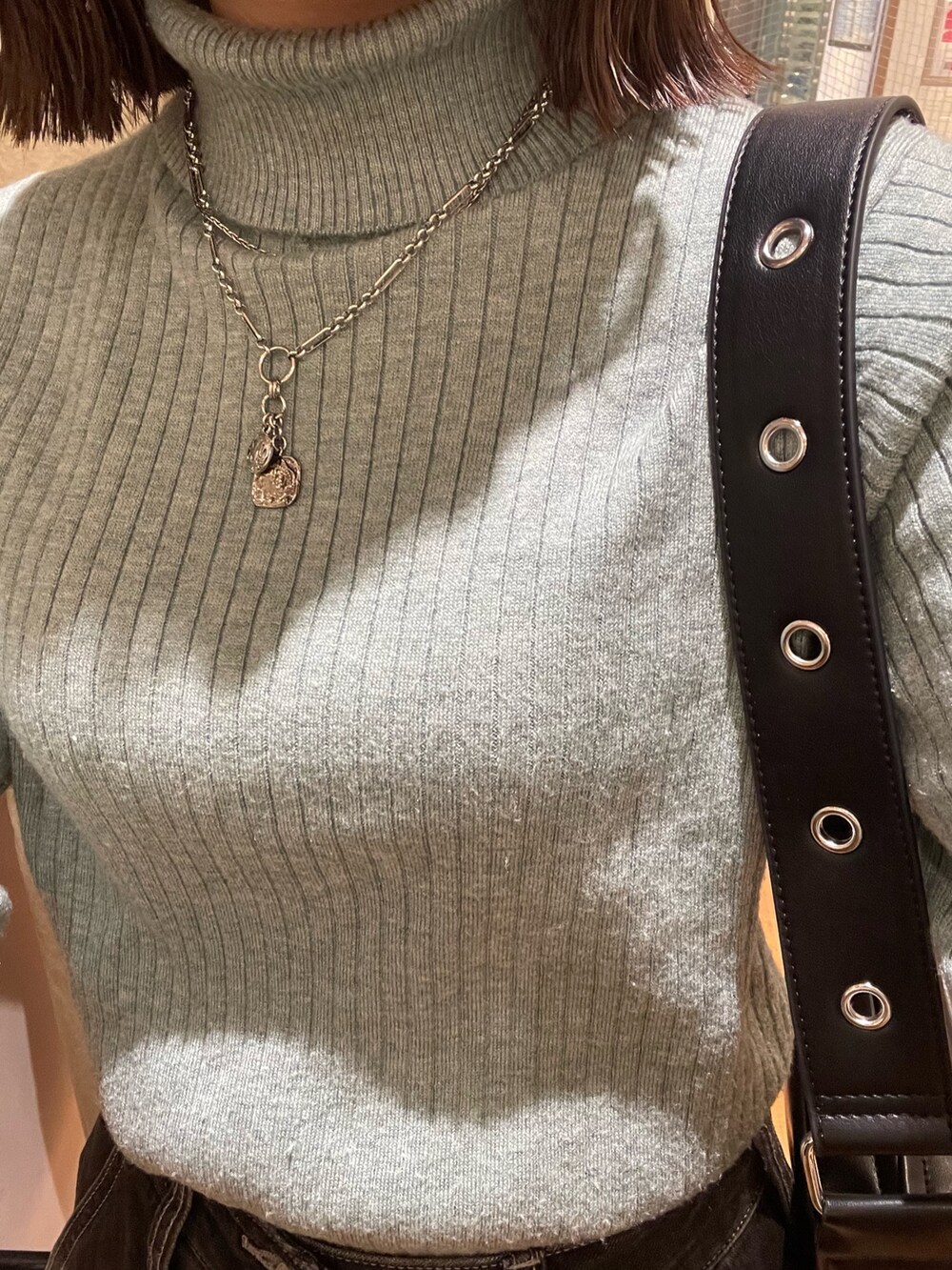 グリーン系のニット/セーター、ブラック系のショルダーバッグ、ブラック系のデニムパンツを着用したレディースの冬コーディネートの8枚目の写真