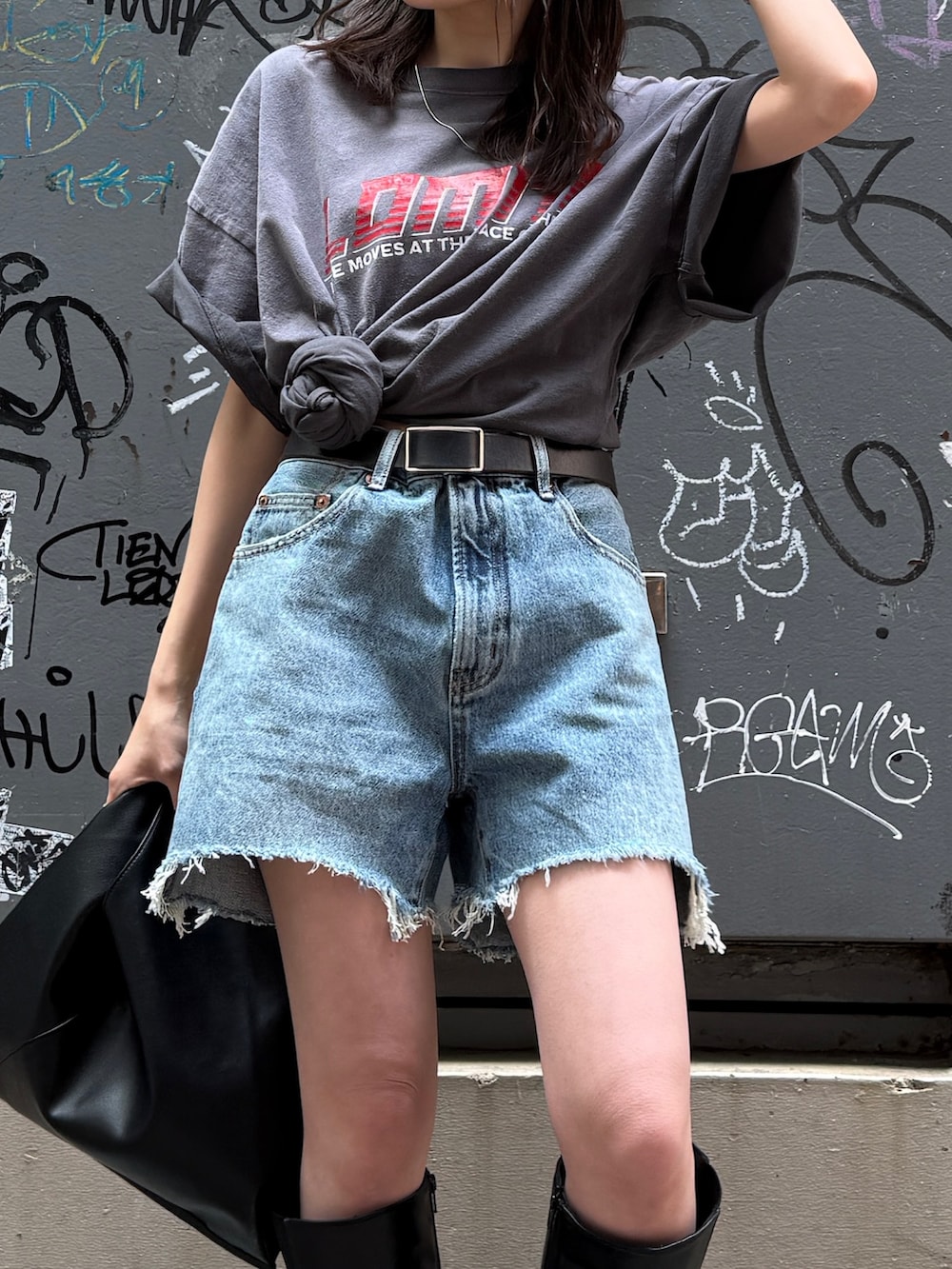 ブルー系のデニムパンツ、グレー系のTシャツ/カットソー、ブラック系のハンドバッグを着用したレディースの春コーディネートの7枚目の写真