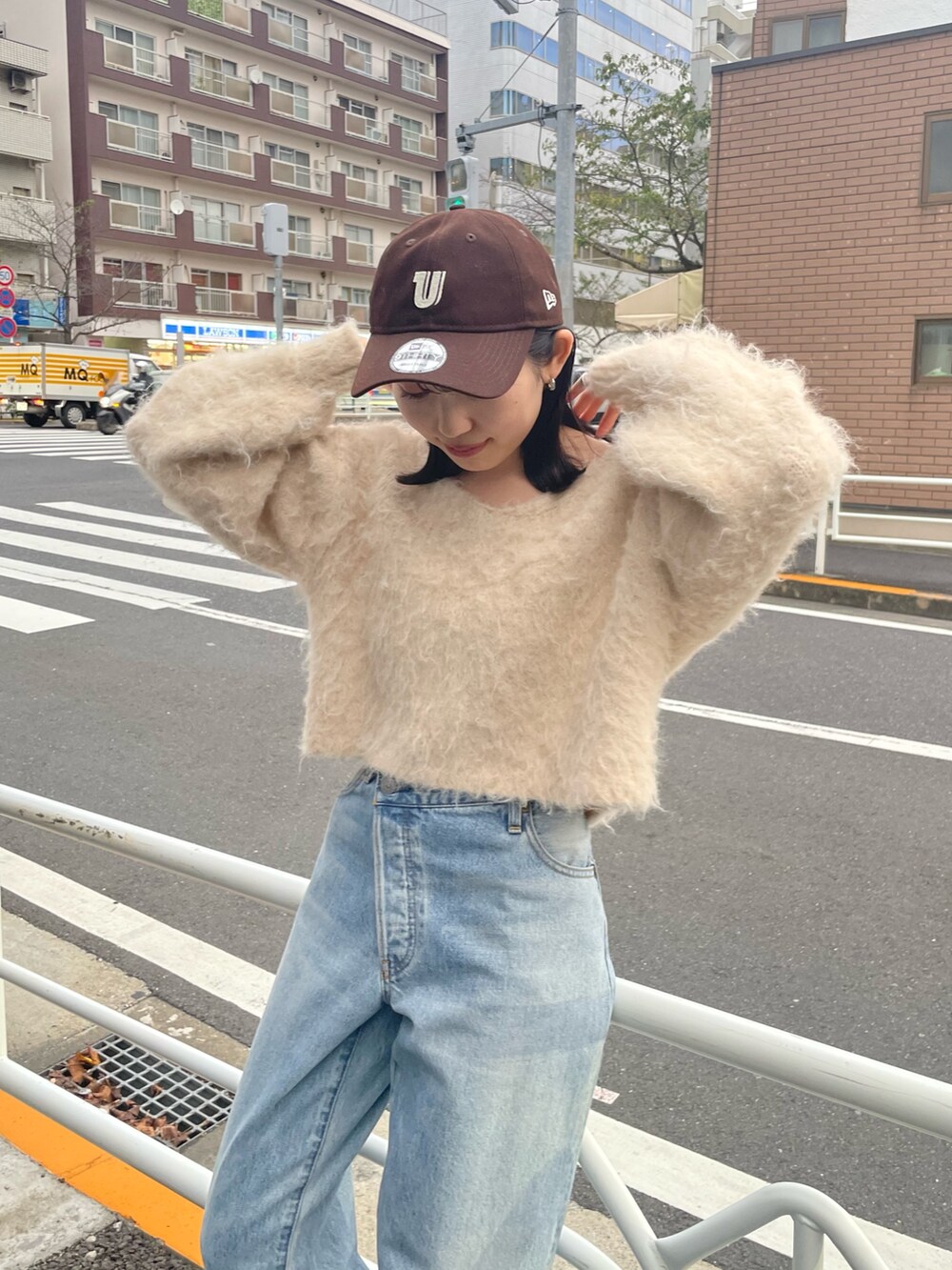 ブラック系のブーツ、ブルー系のデニムパンツ、ホワイト系のニット/セーターを着用したレディースの秋コーディネートの2枚目の写真