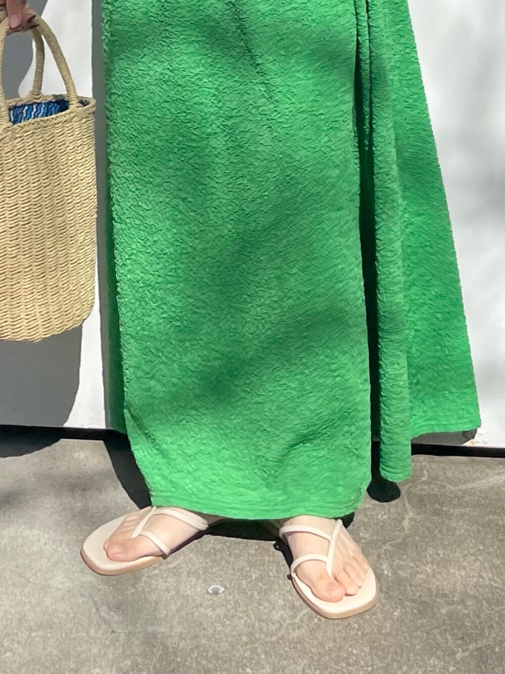 グリーン系のワンピース、ホワイト系のTシャツ/カットソー、ホワイト系のサンダルを着用したレディースの春コーディネートの6枚目の写真