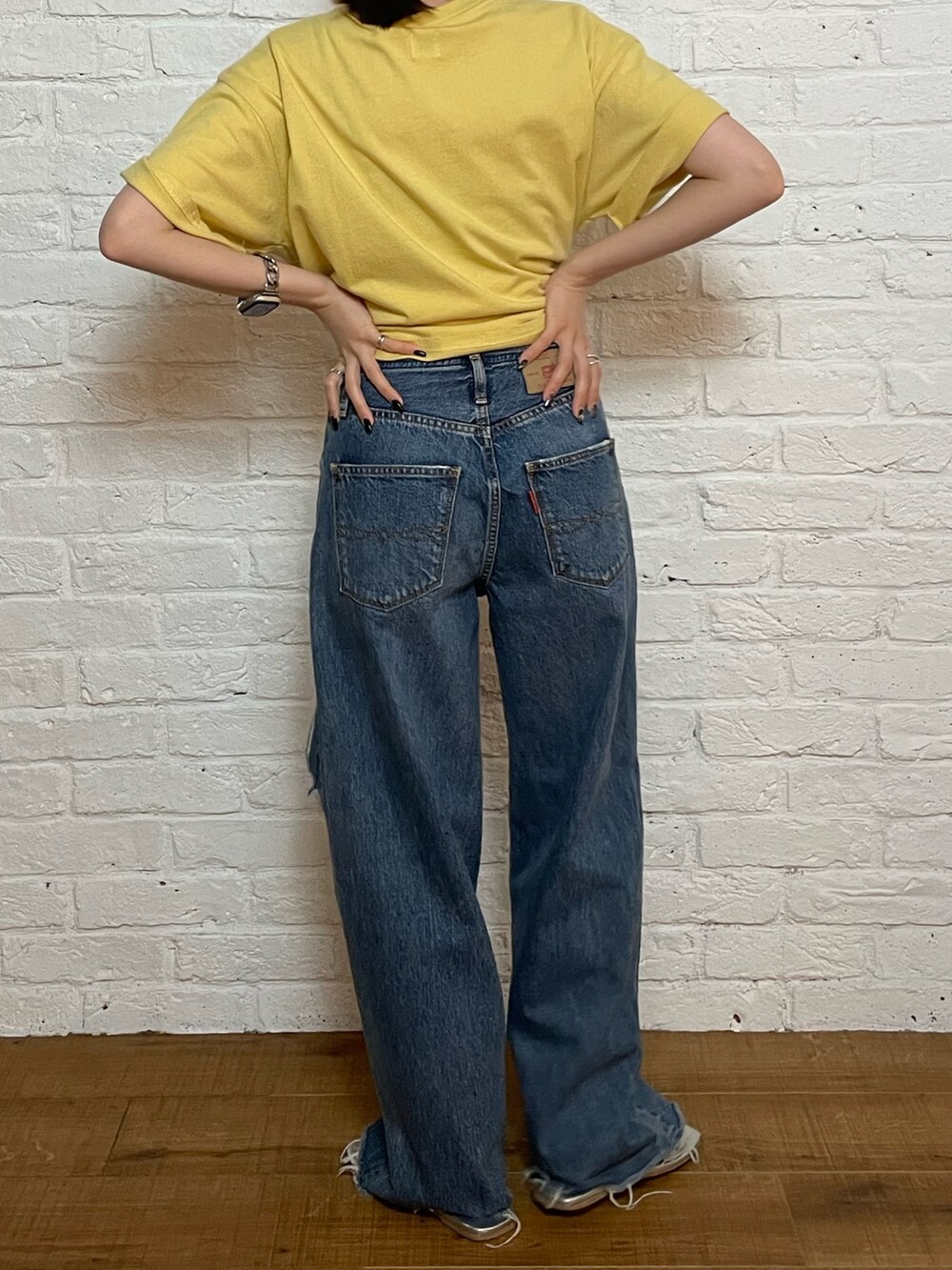 シルバー系のサンダル、ブルー系のデニムパンツ、イエロー系のTシャツ/カットソーを着用したレディースの夏コーディネートの4枚目の写真