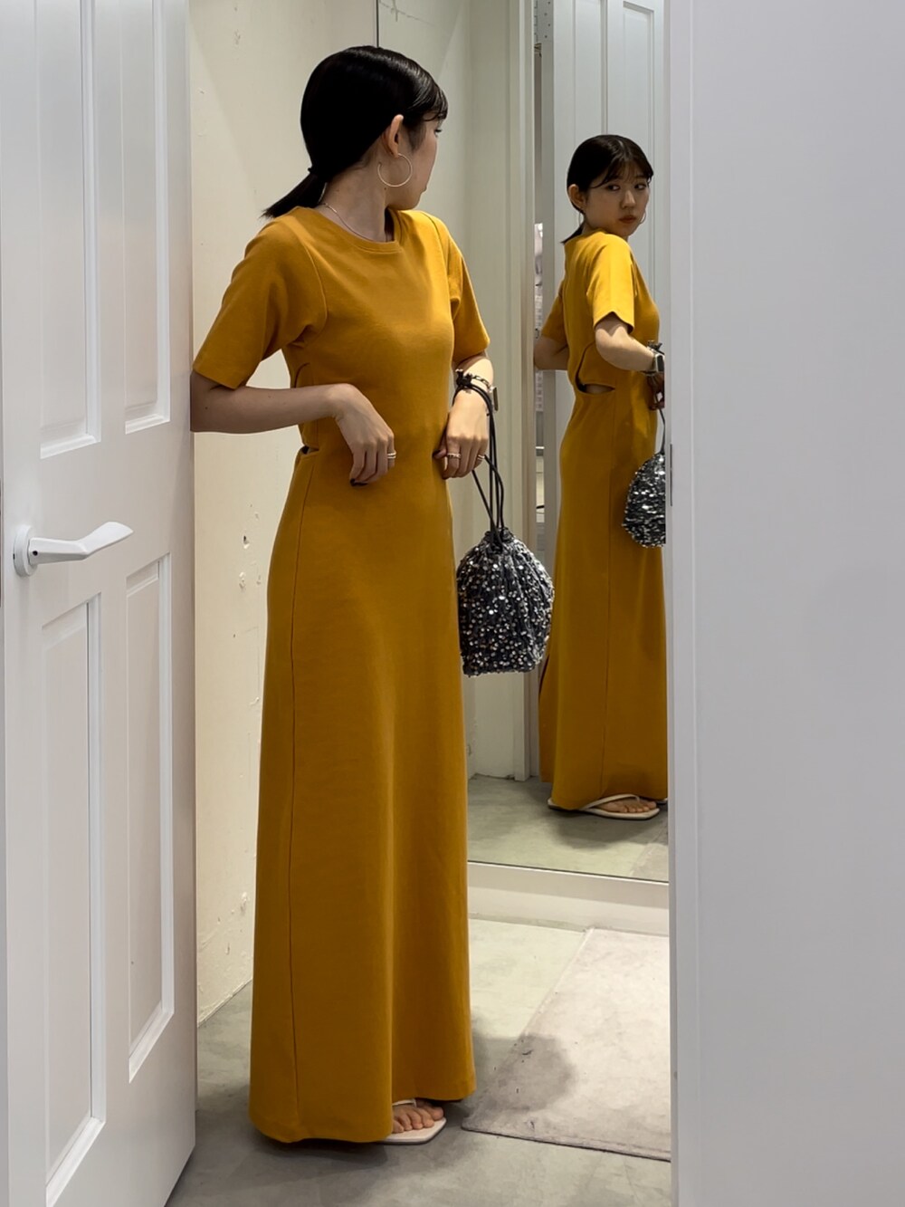 ホワイト系のサンダル、オレンジ系のワンピースを着用したレディースの夏コーディネートの3枚目の写真