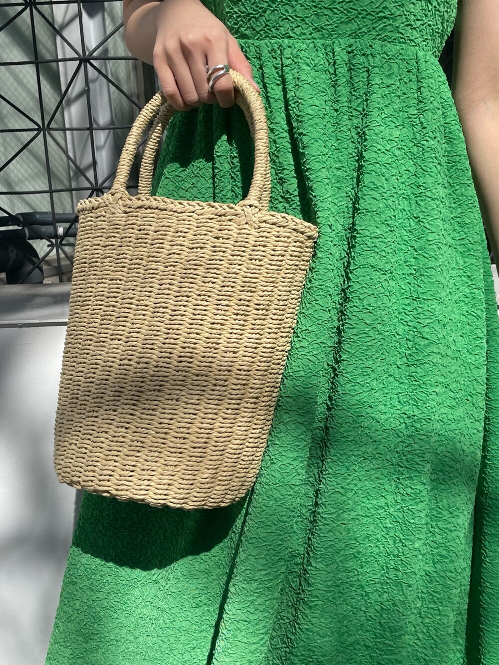 グリーン系のワンピース、ホワイト系のTシャツ/カットソー、ホワイト系のサンダルを着用したレディースの春コーディネートの7枚目の写真