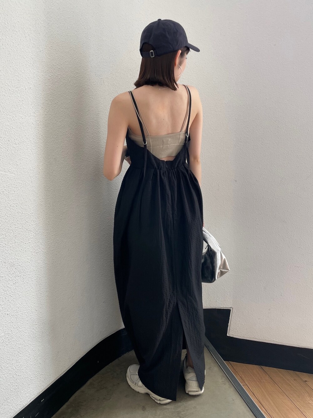 グレー系のキャミソール、シルバー系のハンドバッグ、ブラック系のワンピースを着用したレディースの春コーディネートの5枚目の写真