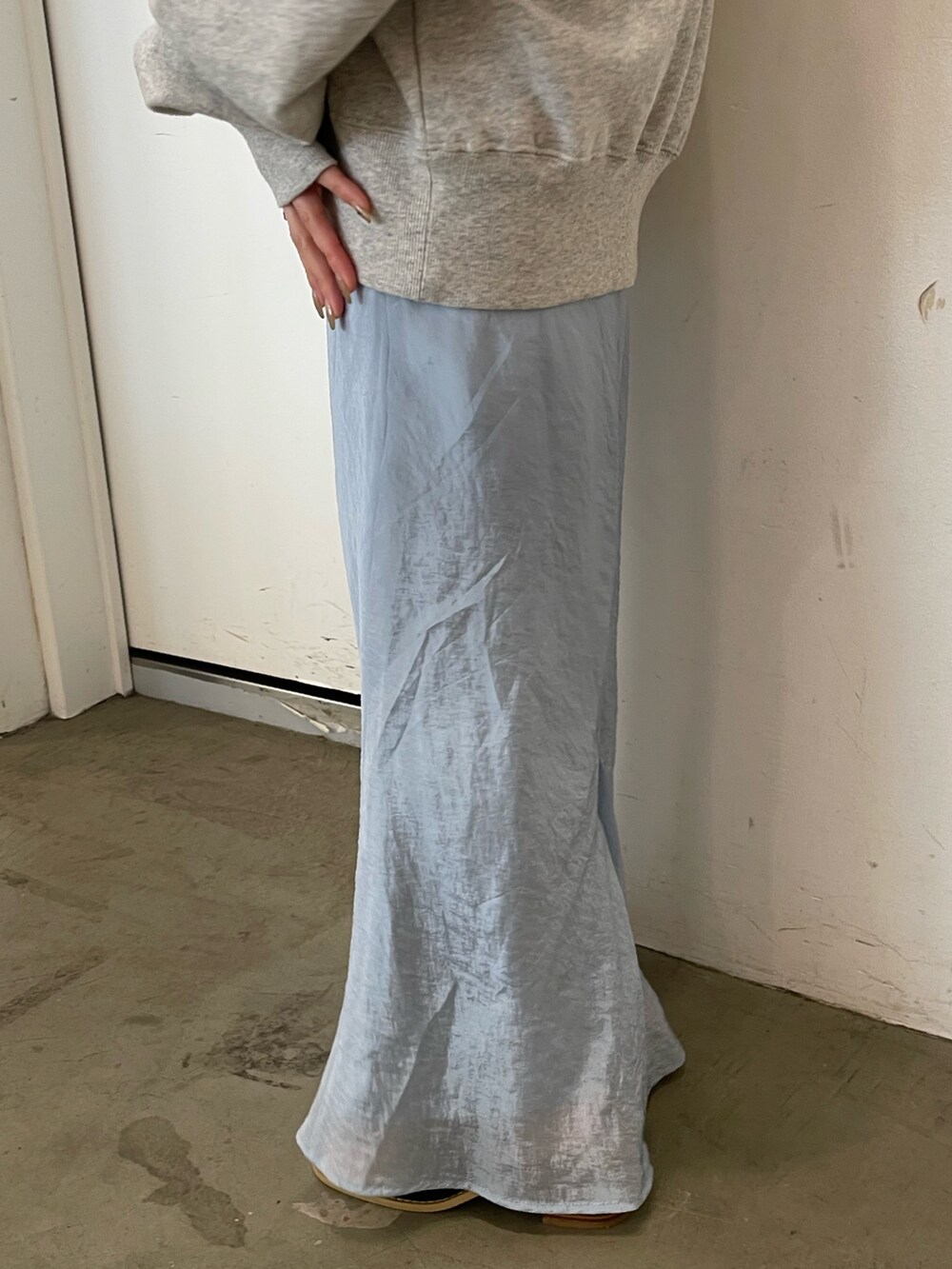 グレー系のスウェット、ブルー系のスカート、ブラック系のサンダルを着用したレディースの冬コーディネートの6枚目の写真