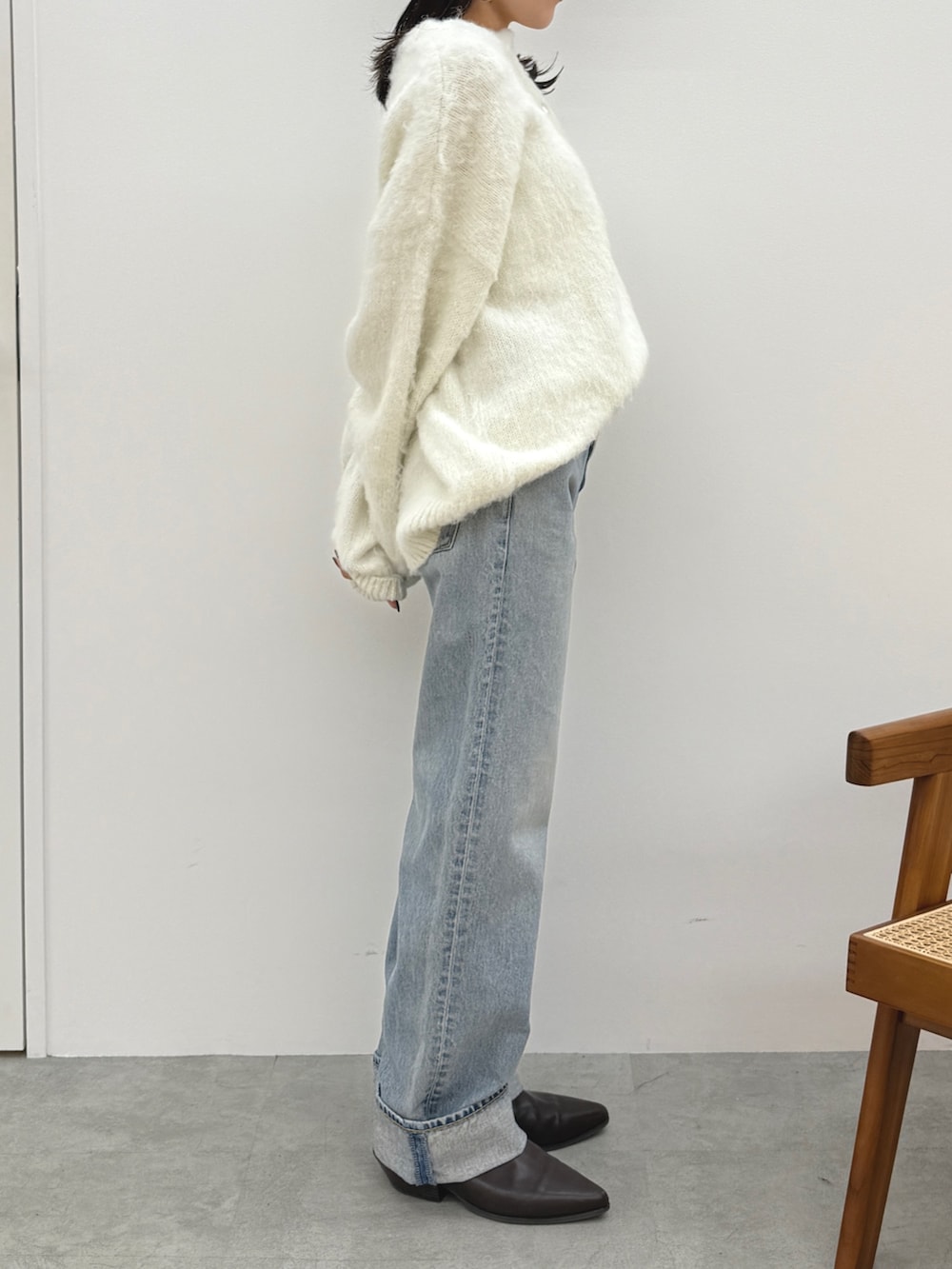 ホワイト系のニット/セーター、ブルー系のデニムパンツ、ブラウン系のブーツを着用したレディースの冬コーディネートの3枚目の写真