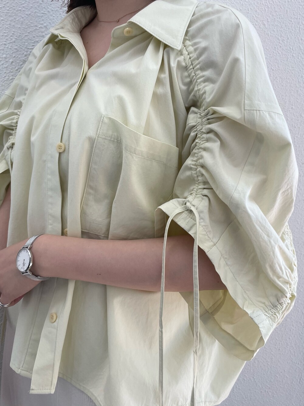 イエロー系のシャツ/ブラウス、ホワイト系のキャミソール、ホワイト系のスカートを着用したレディースの春コーディネートの10枚目の写真