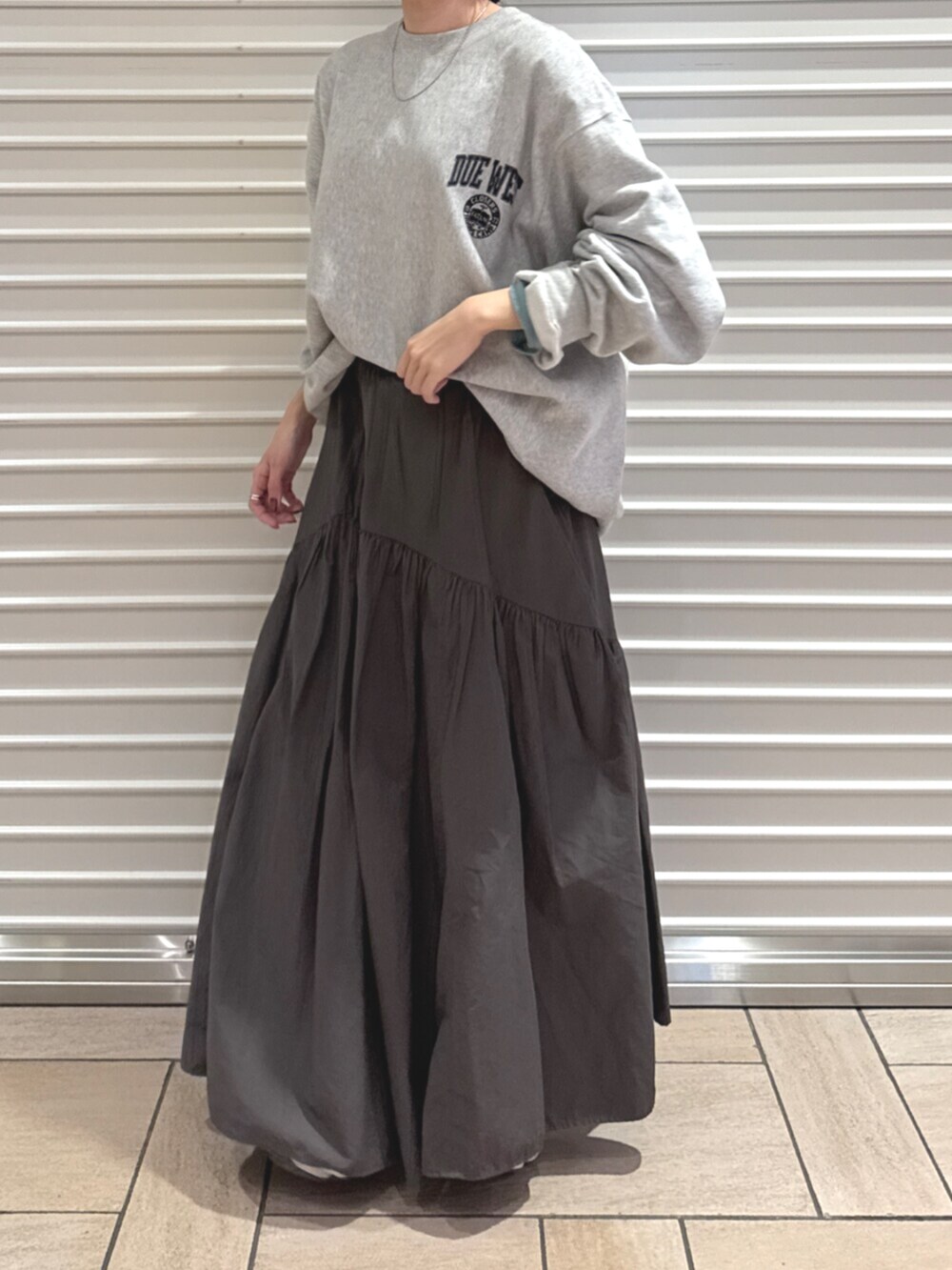 グレー系のスカート、グレー系のスウェットを着用したレディースの秋コーディネートの4枚目の写真