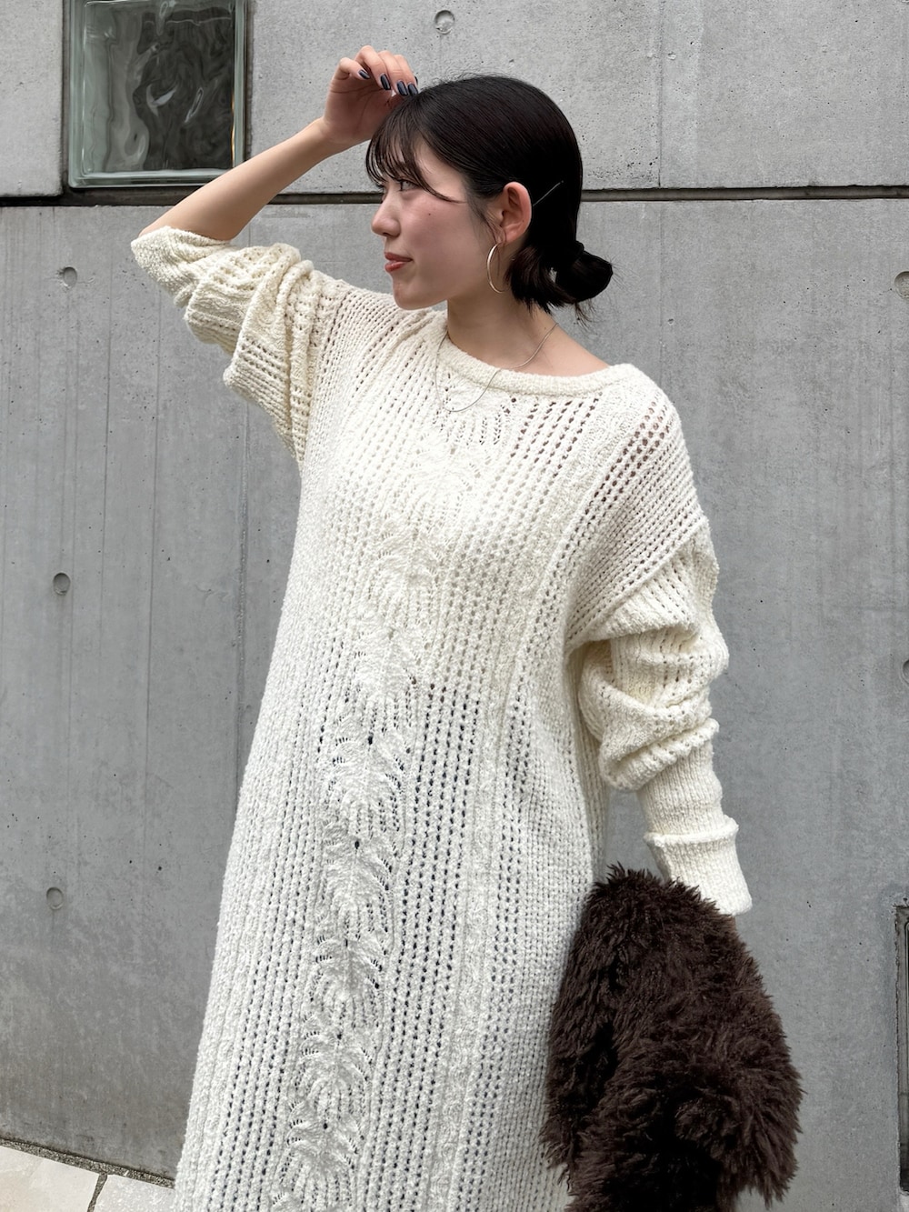 ホワイト系のワンピース、ブルー系のデニムパンツ、ブラウン系のブーツを着用したレディースの冬コーディネートの6枚目の写真