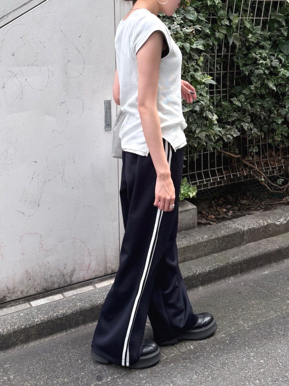 シルバー系のハンドバッグ、ブルー系のその他パンツ、ホワイト系のTシャツ/カットソーを着用したレディースの夏コーディネートの6枚目の写真