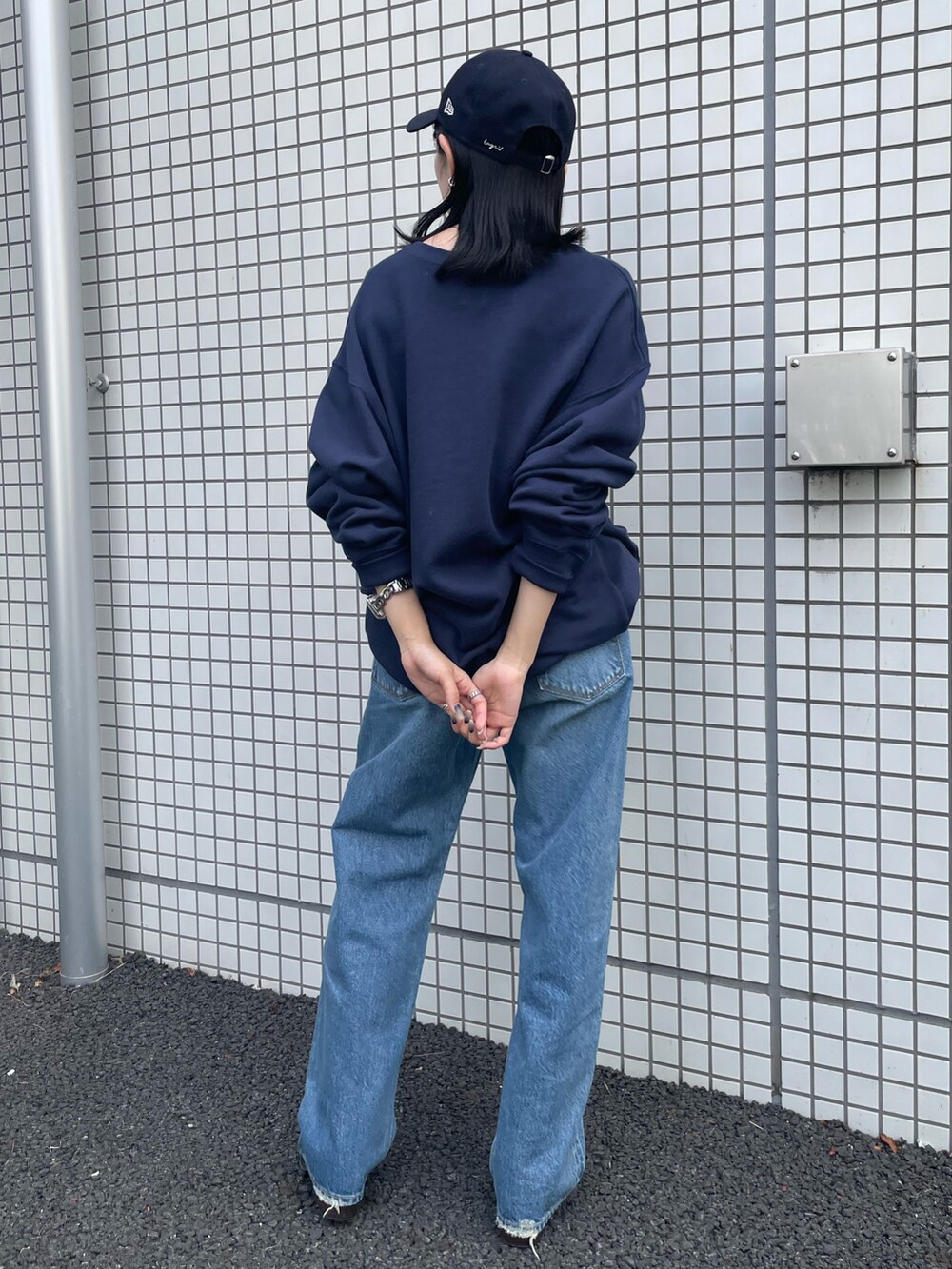 ブラック系のブーツ、ブルー系のスウェット、ブルー系のデニムパンツを着用したレディースの冬コーディネートの5枚目の写真