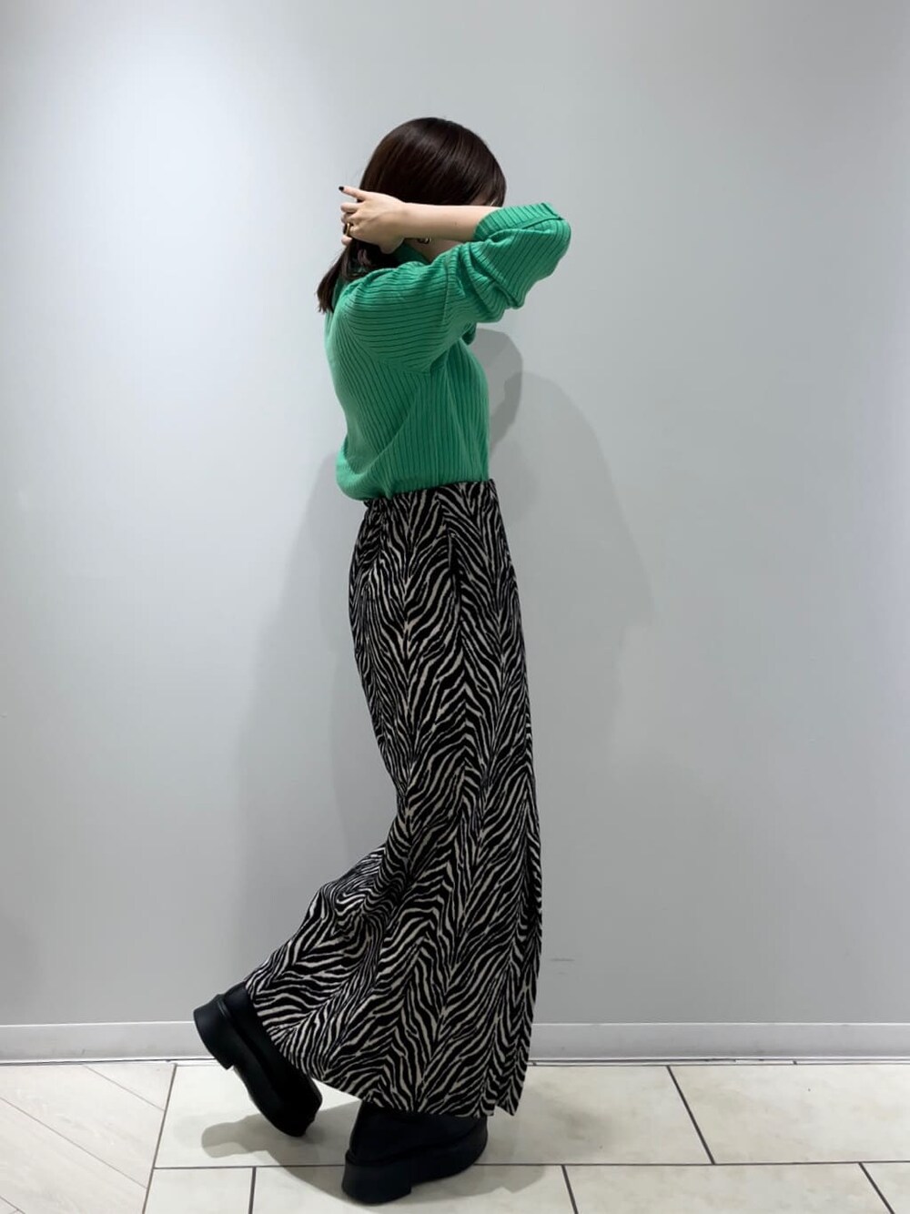 ホワイト系のハンドバッグ、グリーン系のニット/セーター、ブラック系のスカートを着用したレディースの秋コーディネートの4枚目の写真