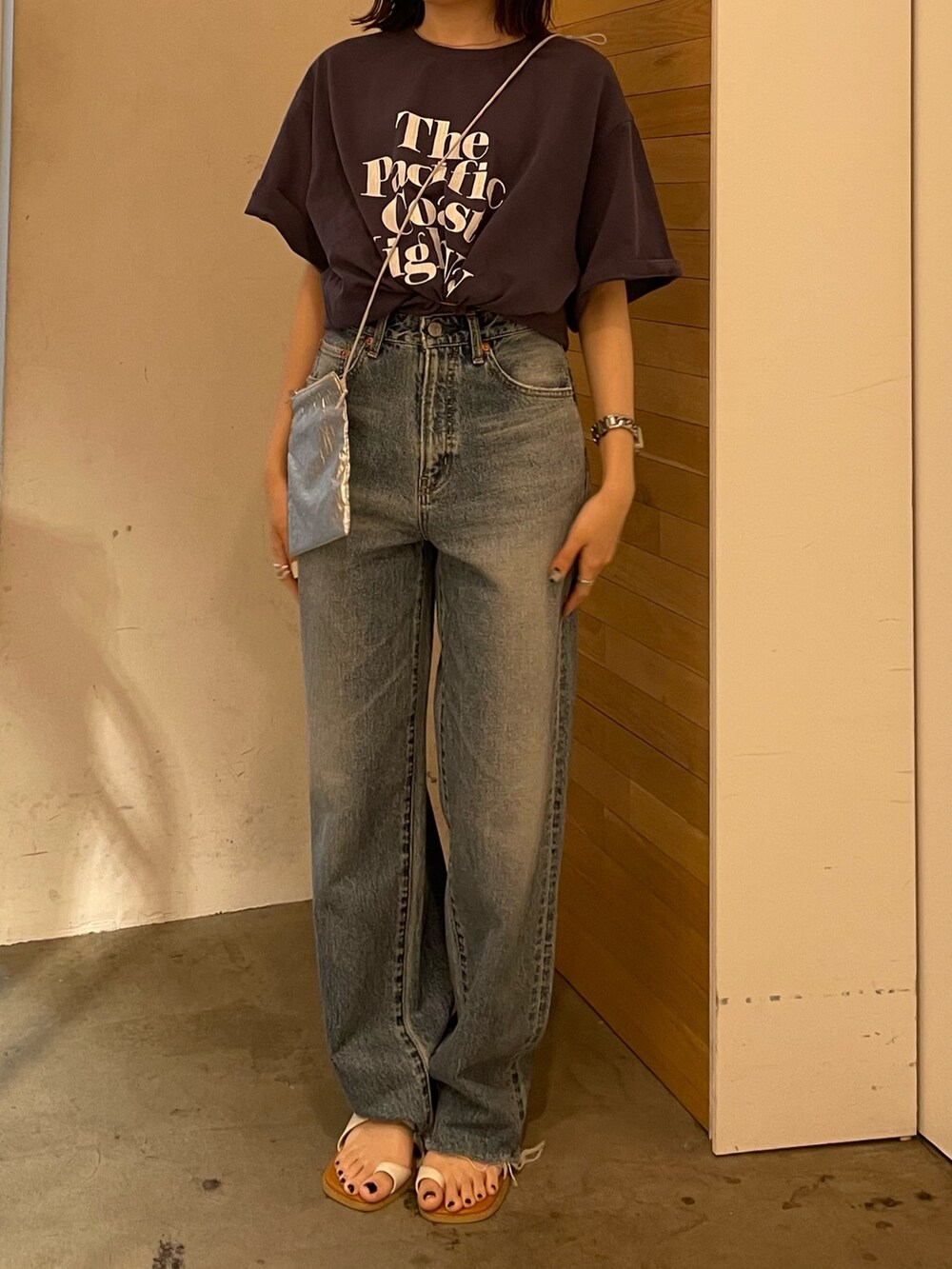 ホワイト系のサンダル、ブルー系のデニムパンツ、シルバー系のショルダーバッグを着用したレディースの春コーディネートの7枚目の写真