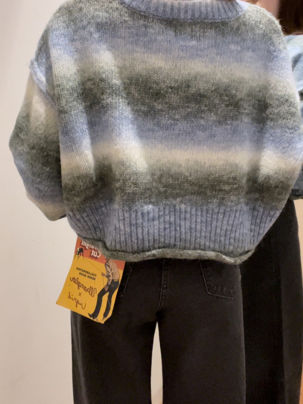 ブラック系のデニムパンツ、ブルー系のニット/セーターを着用したレディースの秋コーディネートの3枚目の写真