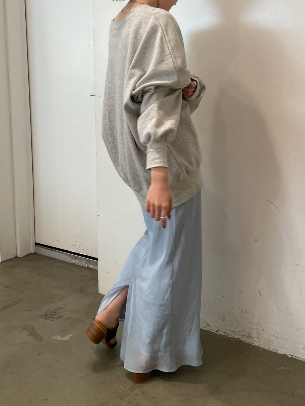 グレー系のスウェット、ブルー系のスカート、ブラック系のサンダルを着用したレディースの冬コーディネートの7枚目の写真