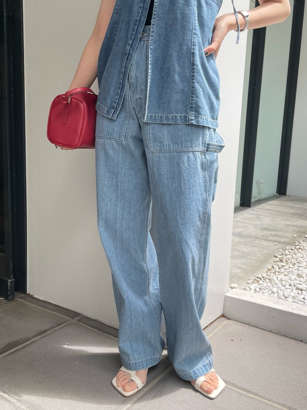 レッド系のハンドバッグ、ホワイト系のサンダル、ブルー系のキャミソールを着用したレディースの春コーディネートの7枚目の写真