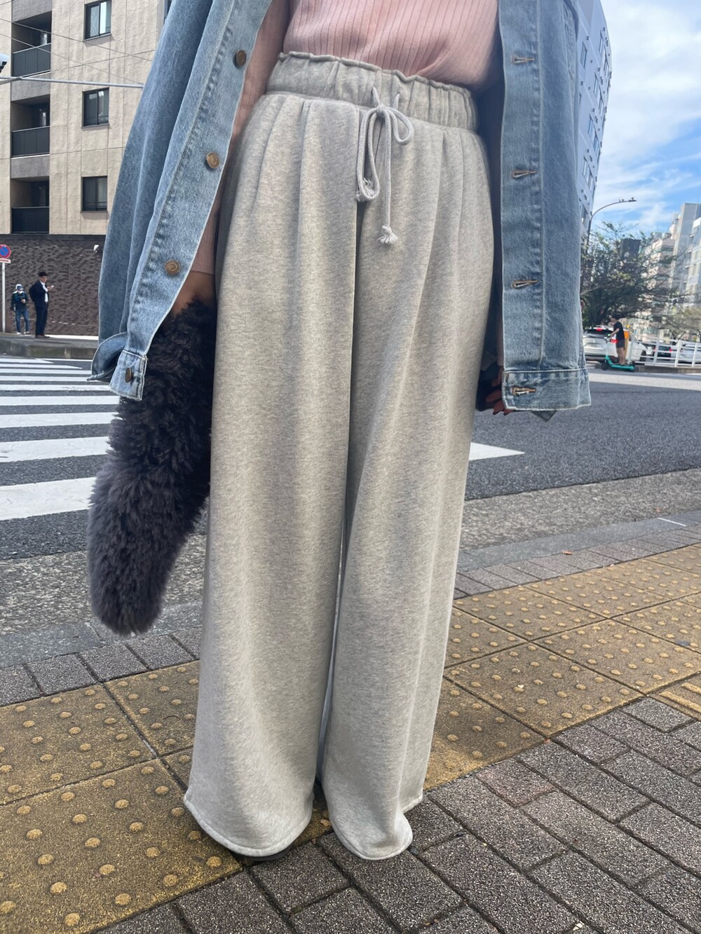 ピンク系のニット/セーター、グレー系のハンドバッグ、グレー系のスウェットパンツを着用したレディースの秋コーディネートの8枚目の写真