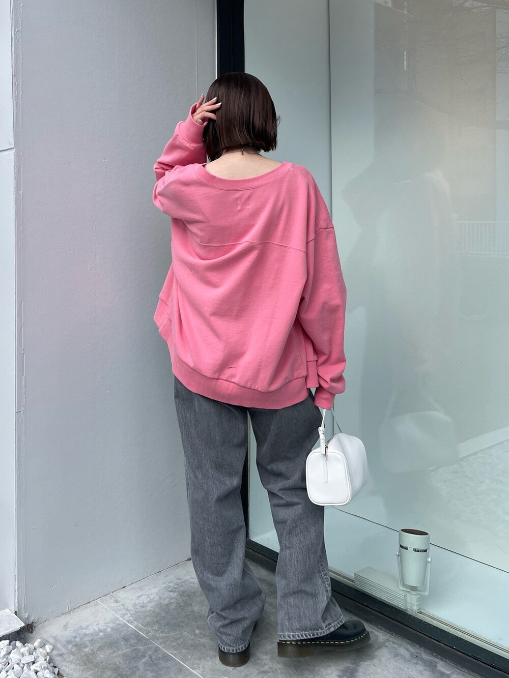 ピンク系のカーディガン/ボレロ、ホワイト系のハンドバッグ、ブラック系のデニムパンツを着用したレディースの冬コーディネートの4枚目の写真