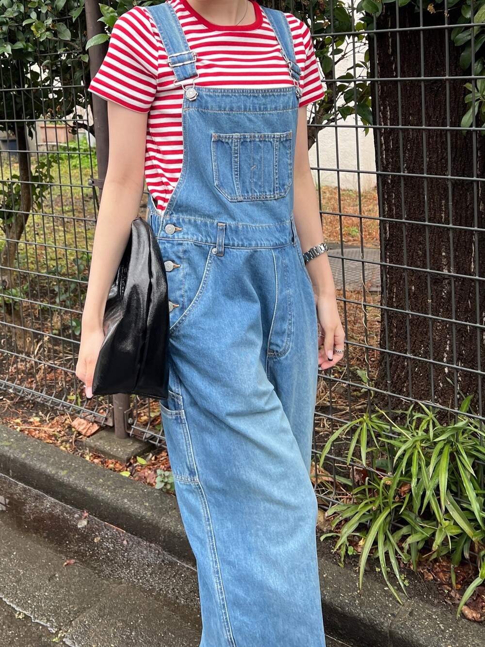 ブラック系のサンダル、ブルー系のつなぎ/オールインワン、レッド系のTシャツ/カットソーを着用したレディースの春コーディネートの4枚目の写真
