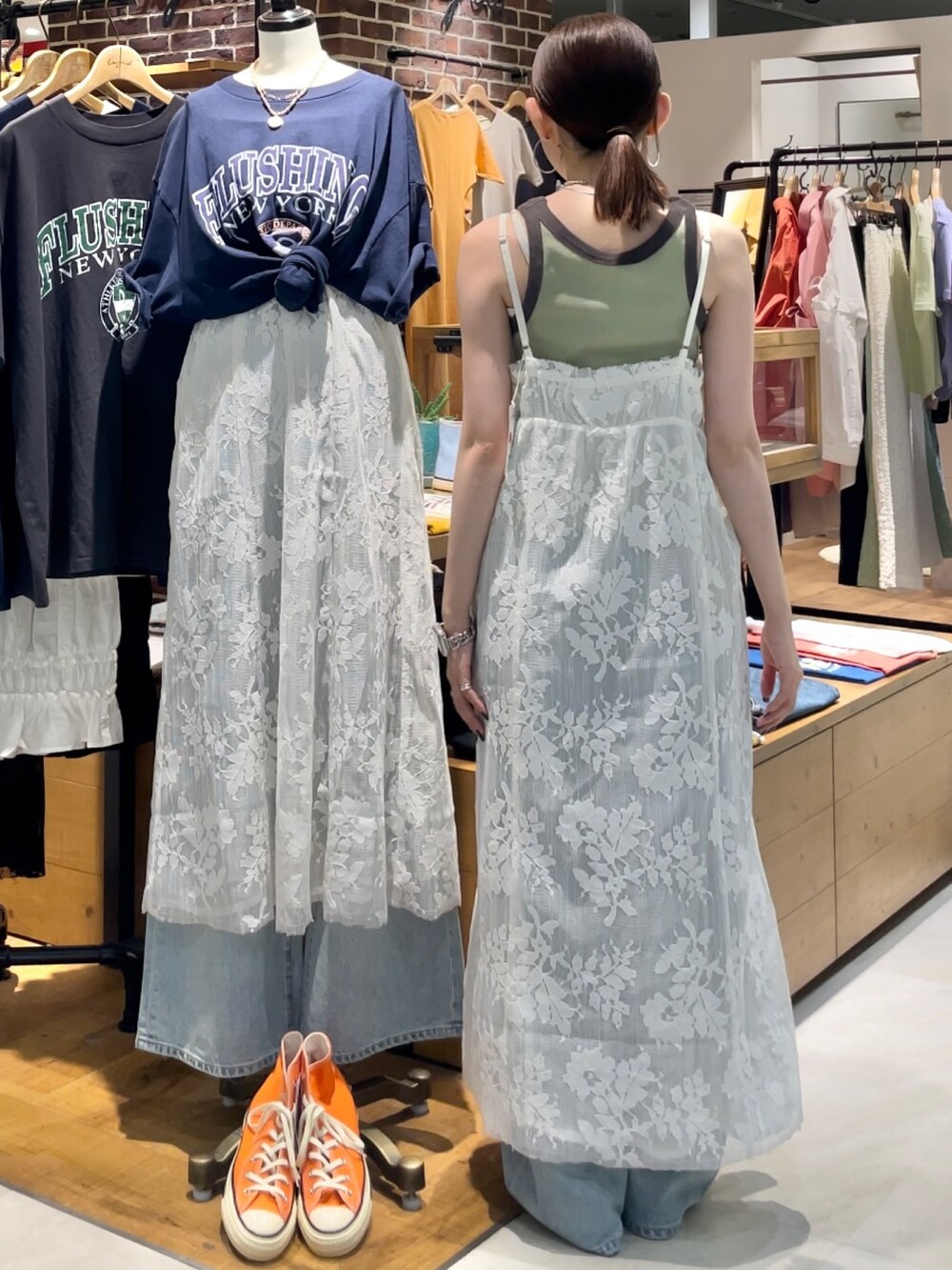 グリーン系のタンクトップ、ブルー系のデニムパンツ、ホワイト系のワンピースを着用したレディースの夏コーディネートの5枚目の写真