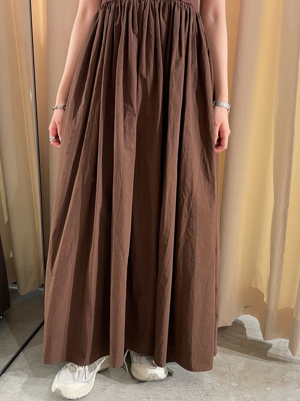 ホワイト系のキャミソール、ブラウン系のワンピース、ゴールド系のネックレスを着用したレディースの春コーディネートの4枚目の写真