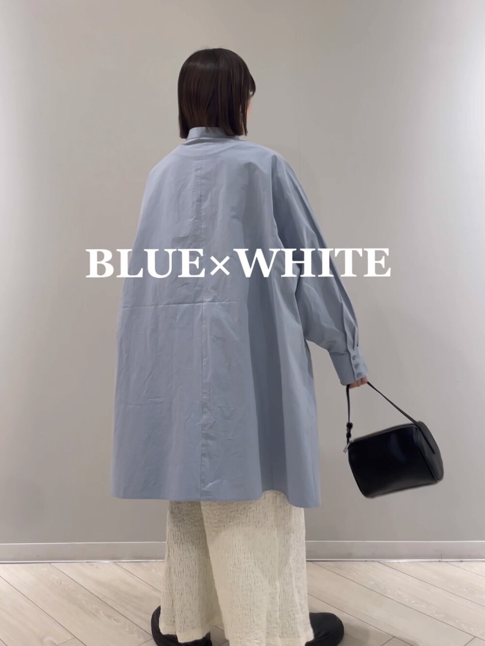 ホワイト系のスカート、ブラック系のハンドバッグ、ブルー系のシャツ/ブラウスを着用したレディースの冬コーディネートの3枚目の写真