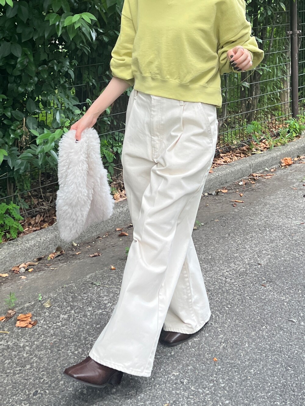 ホワイト系のデニムパンツ、ブラウン系のブーツ、グリーン系のスウェットを着用したレディースの秋コーディネートの7枚目の写真
