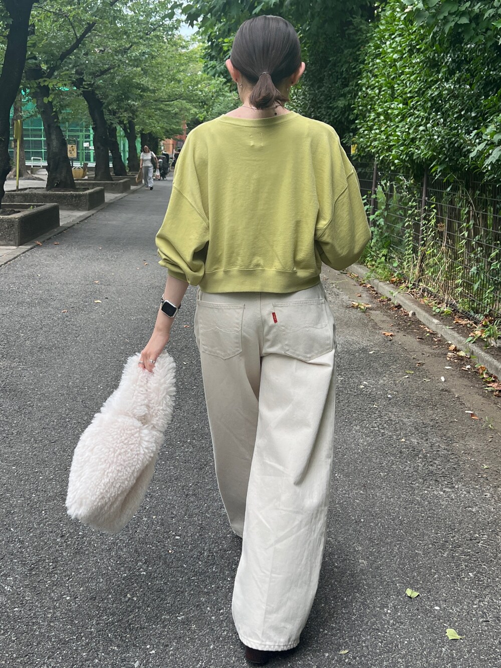 ホワイト系のデニムパンツ、ブラウン系のブーツ、グリーン系のスウェットを着用したレディースの秋コーディネートの4枚目の写真