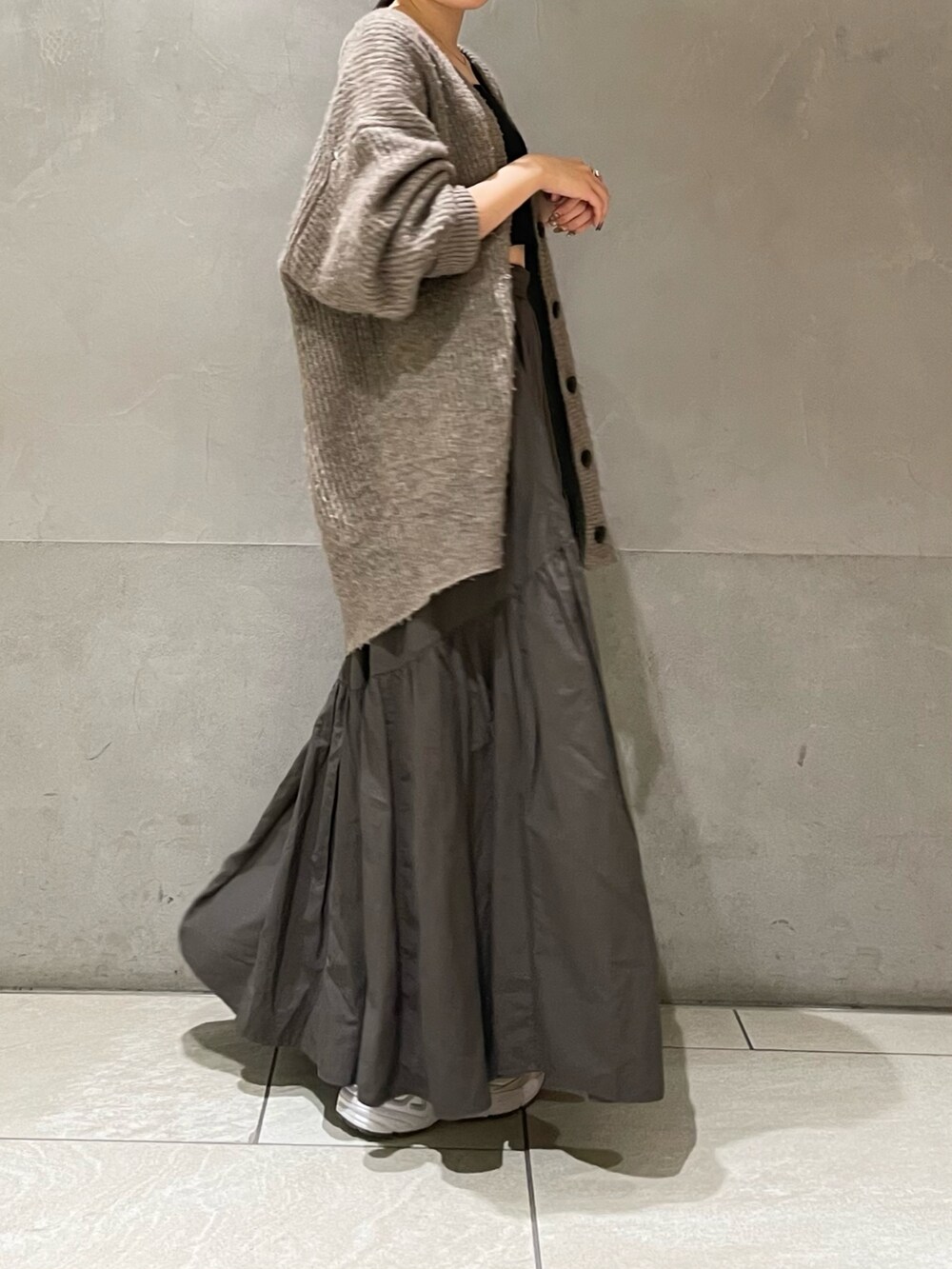 グレー系のカーディガン/ボレロ、グレー系のスカートを着用したレディースの秋コーディネートの3枚目の写真