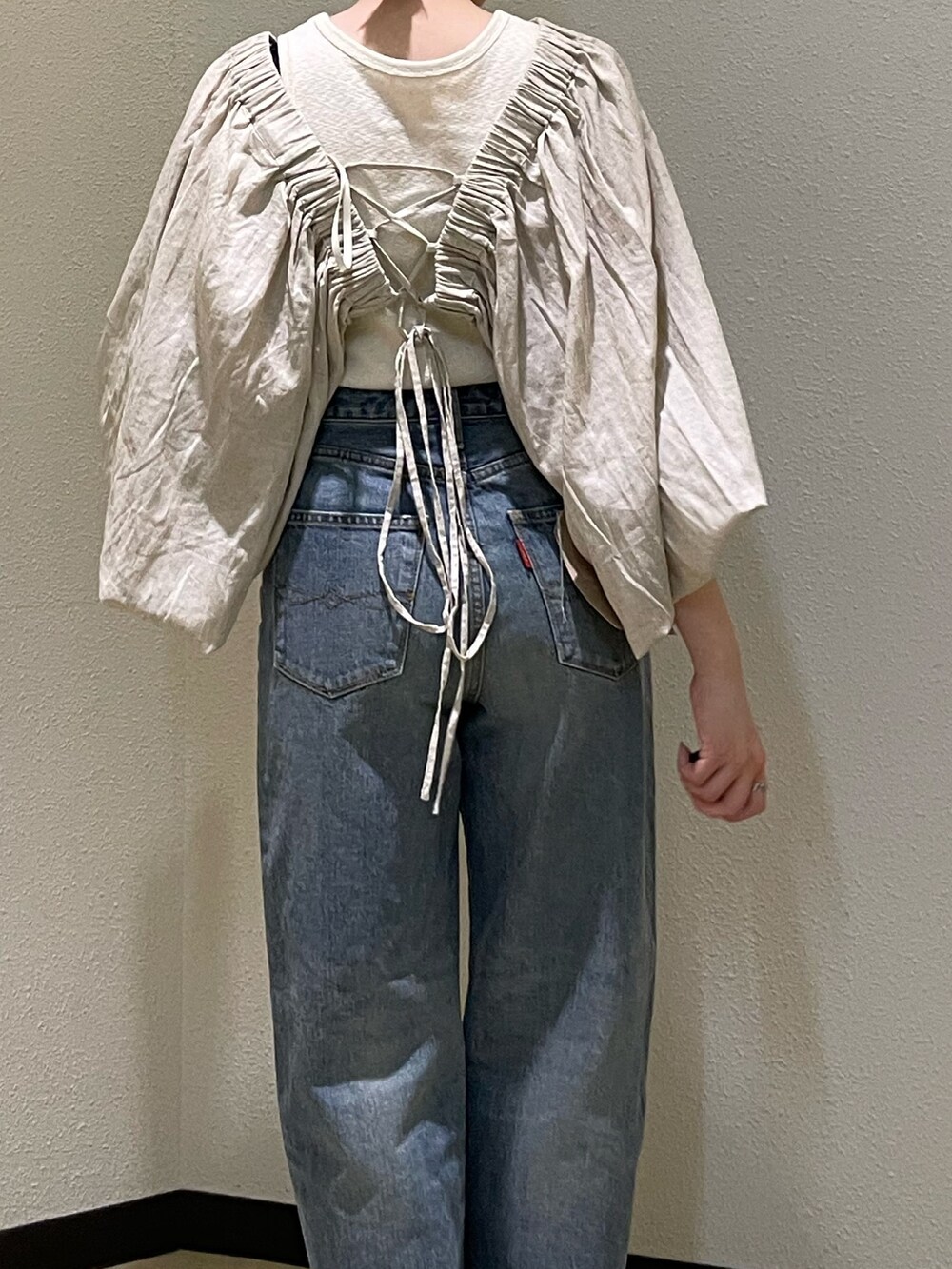 ベージュ系のシャツ/ブラウス、ブルー系のデニムパンツ、ブラック系のサンダルを着用したレディースの春コーディネートの5枚目の写真