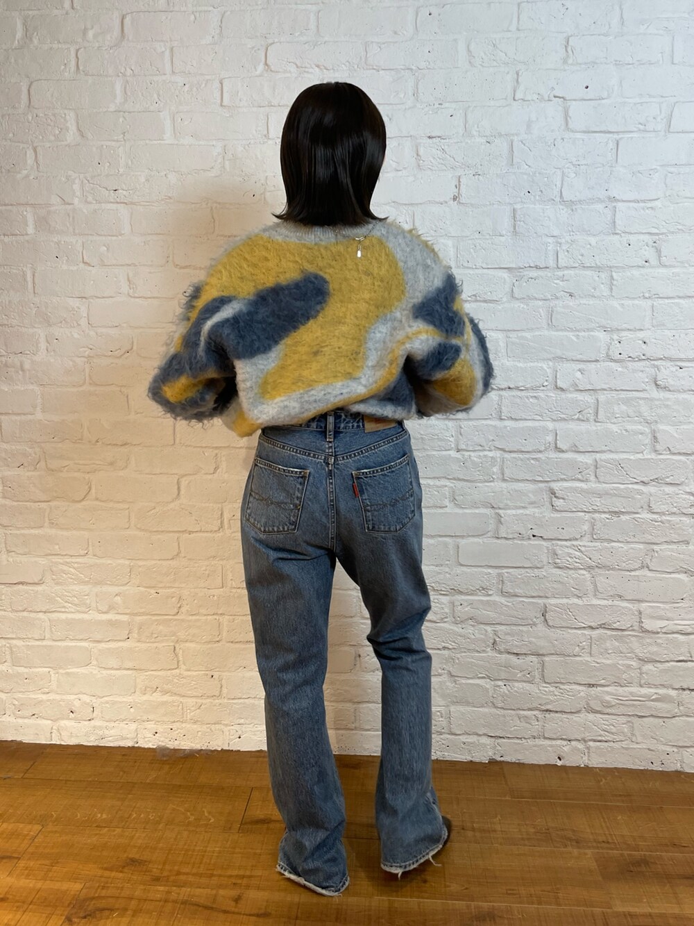 ブルー系のデニムパンツ、ブラック系のブーツ、ブルー系のニット/セーターを着用したレディースの夏コーディネートの3枚目の写真