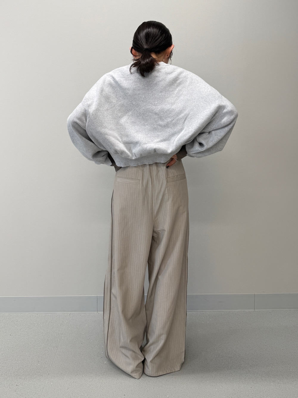 ベージュ系のその他パンツ、グレー系のニット/セーター、ブラック系のブーツを着用したレディースの冬コーディネートの3枚目の写真