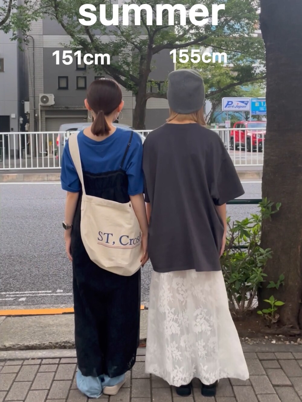 ブラック系のワンピース、ブルー系のデニムパンツ、ブルー系のショルダーバッグを着用したレディースの夏コーディネートの3枚目の写真