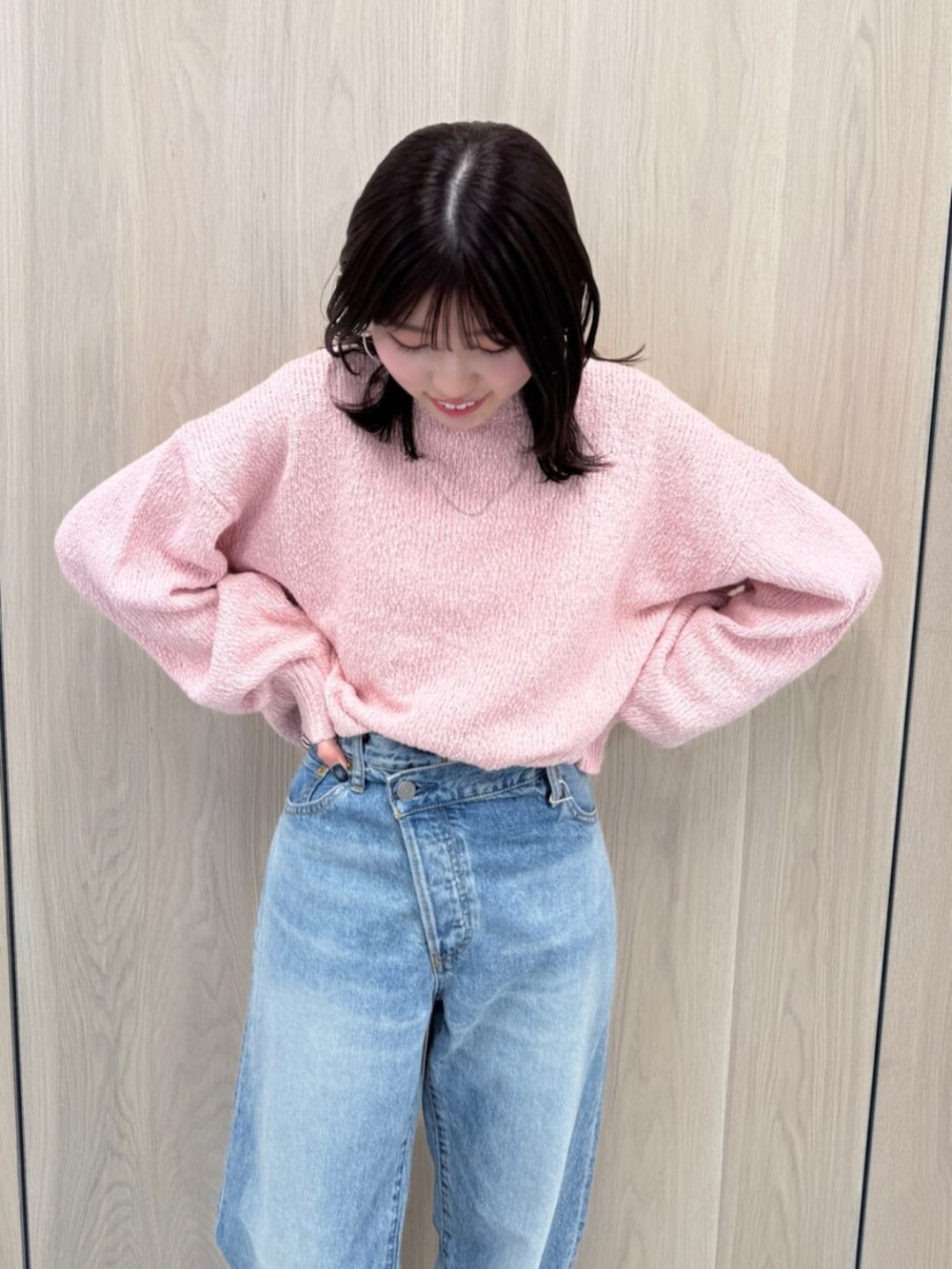 ブルー系のデニムパンツ、ピンク系のニット/セーター、ブラック系のブーツを着用したレディースの冬コーディネートの6枚目の写真