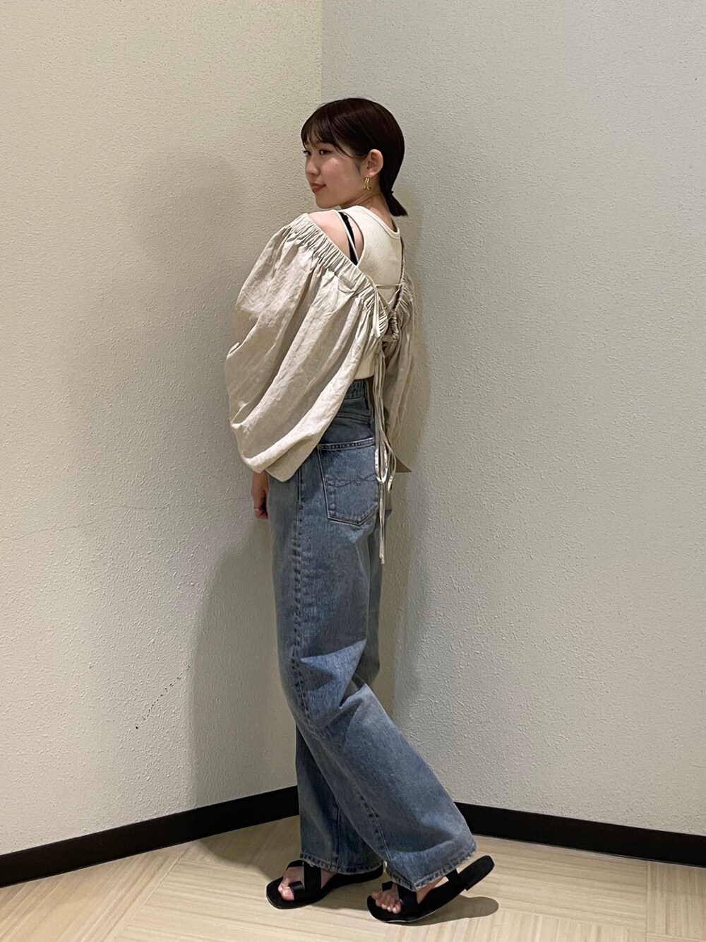 ベージュ系のシャツ/ブラウス、ブルー系のデニムパンツ、ブラック系のサンダルを着用したレディースの春コーディネートの2枚目の写真