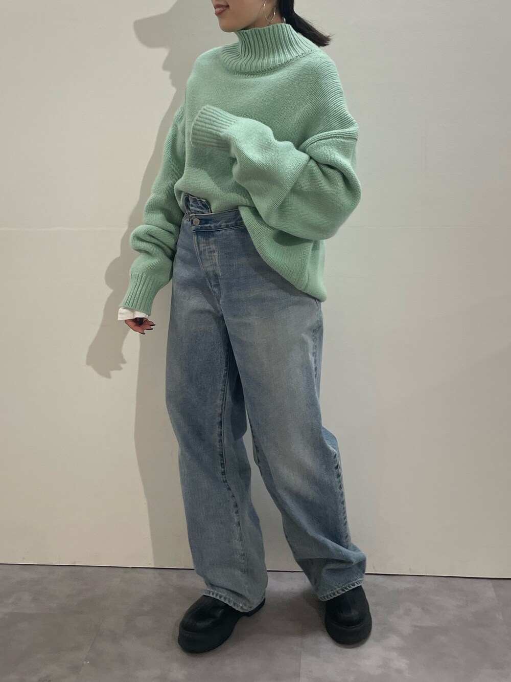 ブルー系のデニムパンツ、ブラック系のブーツ、ホワイト系のTシャツ/カットソーを着用したレディースの冬コーディネートの5枚目の写真